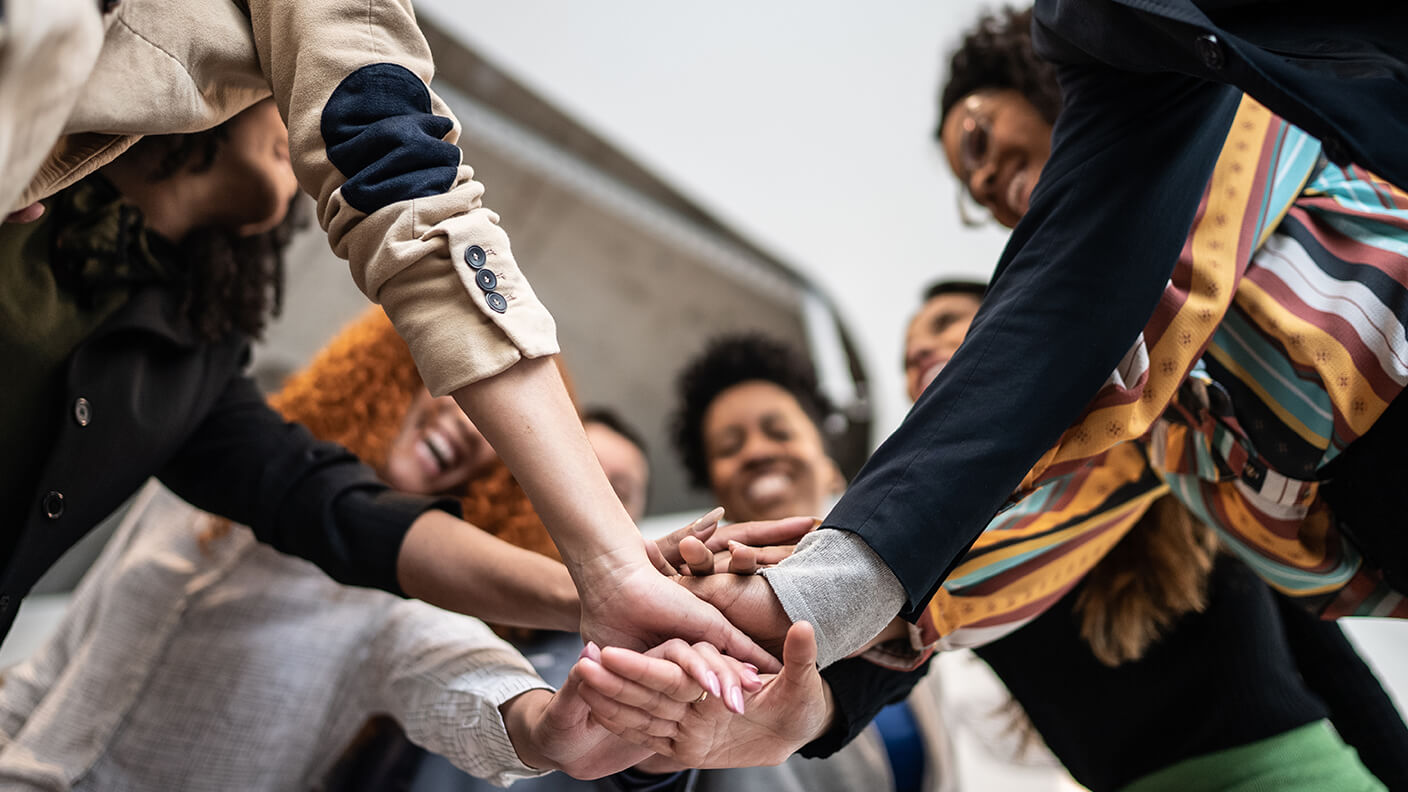 A diverse group of people stacking hands